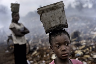 In an e-waste dump that kills nearly everything that it touches, Fati, 8, works with other children searching through hazardous waste in hopes of finding whatever she can to exchange for pennies in order to survive.  (Photograph ©Renée C. Byer)